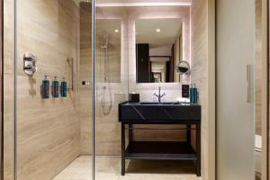 bagno con lavandino e doccia di Hilton Rome Eur La Lama a Roma