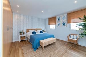 Un dormitorio con una cama azul y una silla. en Ático Cholas by the Beach, en San Miguel de Abona 40 fotos más