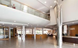 a large lobby with a staircase in a building at Hilton Garden Inn M&aacute;laga in M&aacute;laga