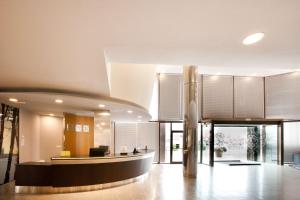 an open lobby with a reception desk in a building at Hilton Garden Inn M&aacute;laga in M&aacute;laga