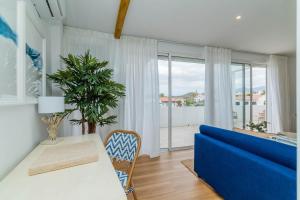 a living room with a blue couch and a table at Ático Cholas by the Beach in San Miguel de Abona