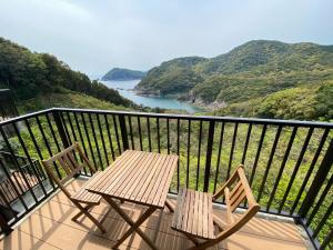 two chairs and a table on a balcony overlooking a river at Hotel Bellreef Otsuki - Vacation STAY 43762v in Otsuki