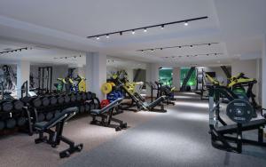 a gym with rows of treadmills and machines at DoubleTree by Hilton Almaty in Almaty