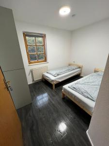 a room with two beds and a window at Monteurzimmer Linz in Linz