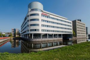 un edificio con un cartello sul lato di un fiume di Hampton by Hilton Amsterdam Airport Schiphol a Hoofddorp