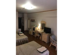 a room with two beds and a desk with a television at Hotel Bellreef Otsuki - Vacation STAY 43772v in Otsuki