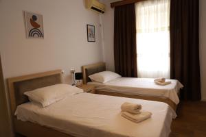 2 Betten in einem Zimmer mit Handtüchern darauf in der Unterkunft Daniel City Center Apartment in Berat