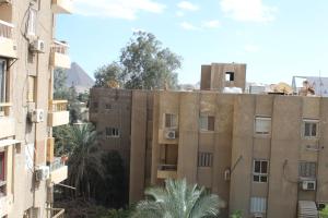 a view of an apartment building with the pyramid in the background at Giza - Pyramids/Museum Apartment in Cairo