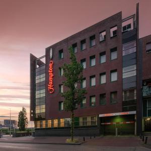 un bâtiment avec un panneau sur son côté dans l'établissement Hampton by Hilton Amsterdam Centre East, à Amsterdam