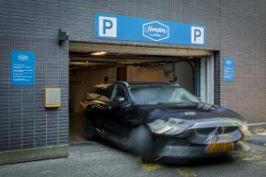 a black car is parked inside of a parking garage at Hampton by Hilton Amsterdam Centre East in Amsterdam