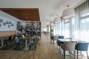 un restaurant avec des tables, des chaises et des fenêtres dans l'établissement Hampton by Hilton Amsterdam Centre East, à Amsterdam