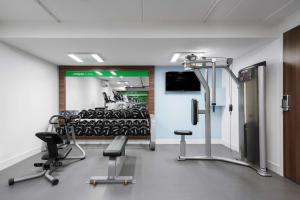 a room with a gym with chairs and a tv at Hampton by Hilton Amsterdam Centre East in Amsterdam