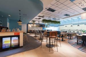 ユトレヒトにあるHampton By Hilton Utrecht Centraal Stationのテーブルと椅子のあるレストラン、バー