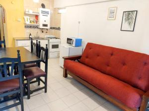 ein Wohnzimmer mit einem roten Sofa und einer Küche in der Unterkunft Grandioso 2 en Barrio Sur in San Miguel de Tucumán