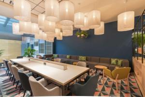 une salle de conférence avec une table, des chaises et des lustres dans l'établissement Hampton By Hilton Utrecht Centraal Station, à Utrecht