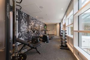 a gym with a row of treadmills and weights at Hampton By Hilton Utrecht Centraal Station in Utrecht