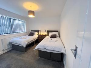 a bedroom with two beds and a window at The Quiet Sanctuary - 4 Bedroom in Swindon