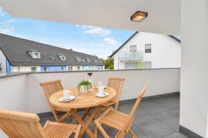 a patio with a wooden table and chairs on a balcony at AT WEINMEISTER - Ankommen & entspannen in Bielefeld