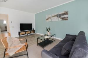 a living room with a couch and a tv at AT WEINMEISTER - Ankommen & entspannen in Bielefeld
