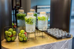 einen Tisch mit drei Gläsern Wasser, Äpfeln und Getränken in der Unterkunft DoubleTree By Hilton Brussels City in Brüssel
