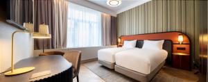 ein Hotelzimmer mit einem Bett, einem Schreibtisch und einem Schreibtisch in der Unterkunft DoubleTree By Hilton Brussels City in Brüssel