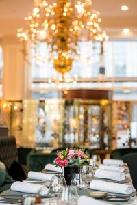 - une table avec des serviettes blanches et des fleurs dans l'établissement Hilton Brussels Grand Place, à Bruxelles