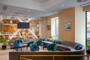 a lobby with a couch and chairs and a tv at Hilton Garden Inn Bucharest Old Town in Bucharest