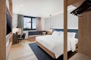 a hotel room with a bed and a couch at Hilton Garden Inn Bucharest Airport in Otopeni +28 photos