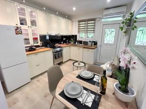 Una cocina con mesa y sillas y un refrigerador. en Garden appartment, en Ioannina