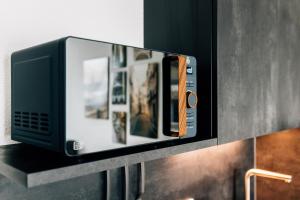 a microwave on a shelf in a kitchen at Modern-Living Stadt-Appartement Mitte in Bielefeld