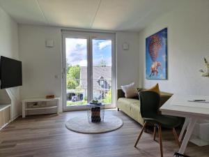 a living room with a couch and a table at Modern-Living Stadt-Appartement Mitte in Bielefeld