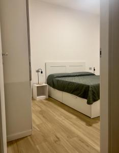 Habitación blanca con cama y espejo en Apartment Lake Varese - Lago di Varese -, en Lomnago