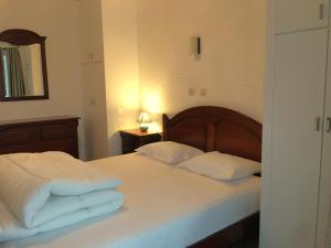 una camera da letto con un letto con lenzuola bianche e uno specchio di Vakantieappartement "The Seagull" vlakbij het strand a Nieuwpoort