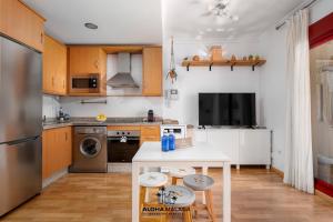- une cuisine avec des placards en bois et une table blanche dans l'établissement Apartamento Imperio Argentina, à Malaga