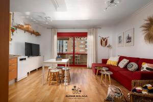 a living room with a red couch and a kitchen at Apartamento Imperio Argentina in Málaga