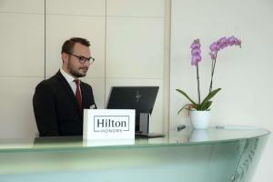 a man sitting at a desk with a laptop at Hilton Florence Metropole in Florence