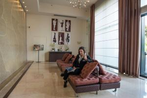 a woman sitting on a couch in a lobby at Hilton Florence Metropole in Florence