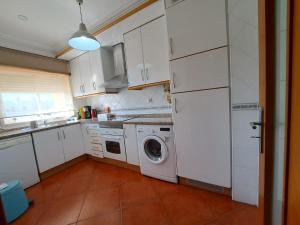 a kitchen with a washing machine and a washer at MSHomes Corcovada in Albufeira