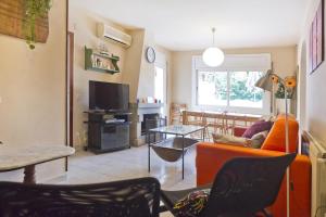 a living room with an orange couch and a table at Verdaguer Home in Castelldefels