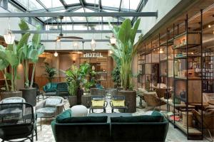 una biblioteca con sofás, sillas y plantas en DoubleTree By Hilton Rome Monti, en Roma