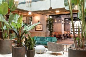 a lobby with a green couch and plants at DoubleTree By Hilton Rome Monti in Rome