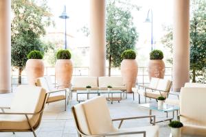 une chambre avec des chaises, des tables et des vases dans l'établissement Hilton Garden Inn Florence Novoli, à Florence