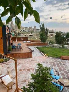 a patio with chairs and tables and a view of a city at Cappatiny House in Goreme