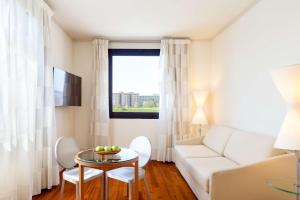 uma sala de estar com um sofá branco e uma mesa em Hilton Garden Inn Florence Novoli em Florença