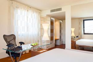 a bedroom with a bed and a desk and a mirror at Hilton Garden Inn Florence Novoli in Florence