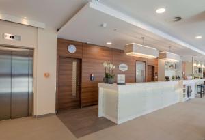 a lobby with a reception area with a clock on the wall at Hampton by Hilton Frankfurt City Centre in Frankfurt/Main