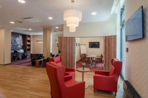 a lobby with red chairs and a waiting room at Hampton by Hilton Frankfurt City Centre in Frankfurt/Main +22 photos
