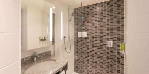 a bathroom with a sink and a shower at Hampton by Hilton Frankfurt City Centre in Frankfurt/Main