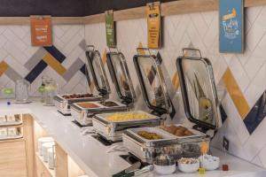 美因河畔法兰克福Hampton By Hilton Frankfurt Airport的柜台上的自助餐,包括食品托盘 更多20张照片
