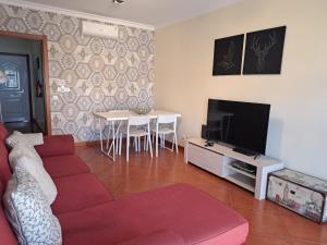 a living room with a couch and a tv and a table at MSHomes Corcovada in Albufeira